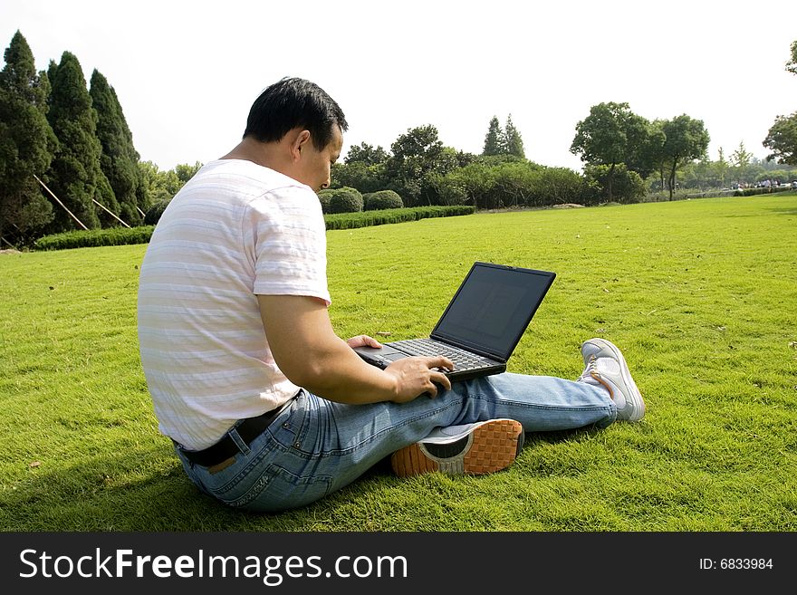 A young man using a laptop outdoors