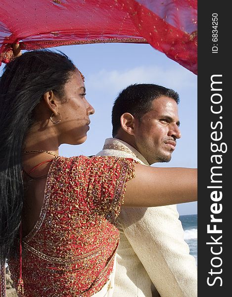 A couple after their wedding looking out at sea from under the veil. A couple after their wedding looking out at sea from under the veil.