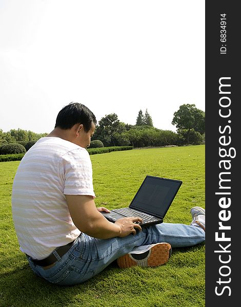 A young man using a laptop outdoors