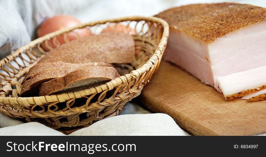 Bread is in a straw small basket, alongside pork fat