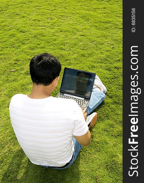 A young man using a laptop outdoors