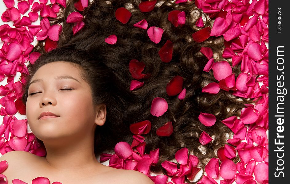 Asian girl with long hair and rose petals