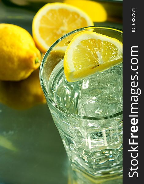 Glass of fresh water with cubes of ice and lemon