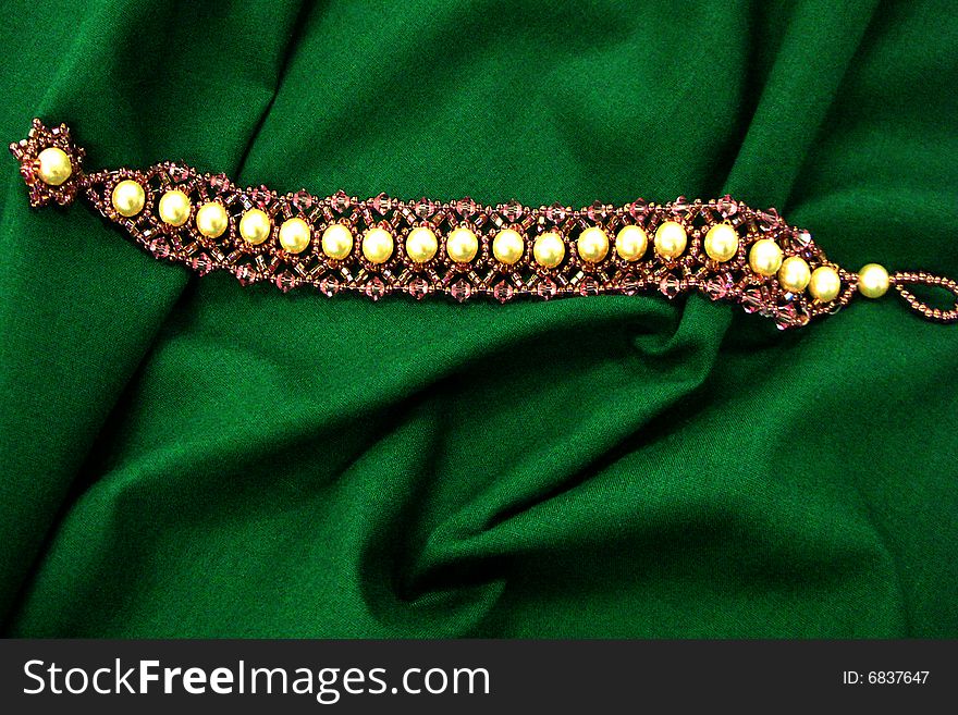 Pearl bracelet on draped green fabric