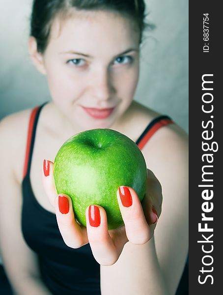 Young beautiful girl holding a green apple. Young beautiful girl holding a green apple