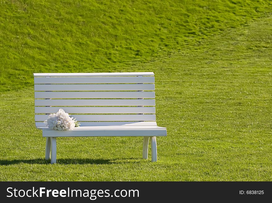 White wedding bench on the green grass. White wedding bench on the green grass