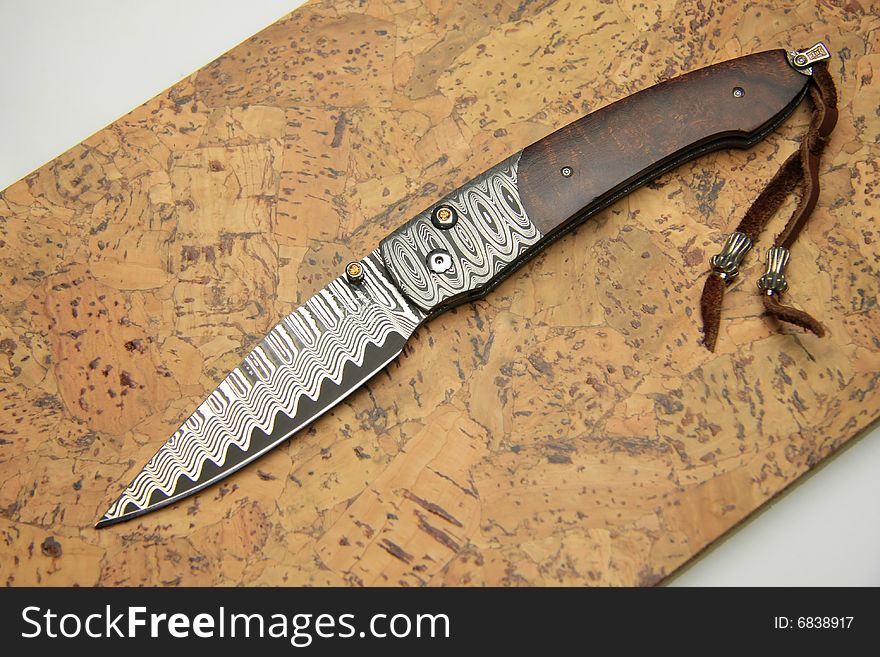 Stainless steel pocket knife isolated on the wood background
