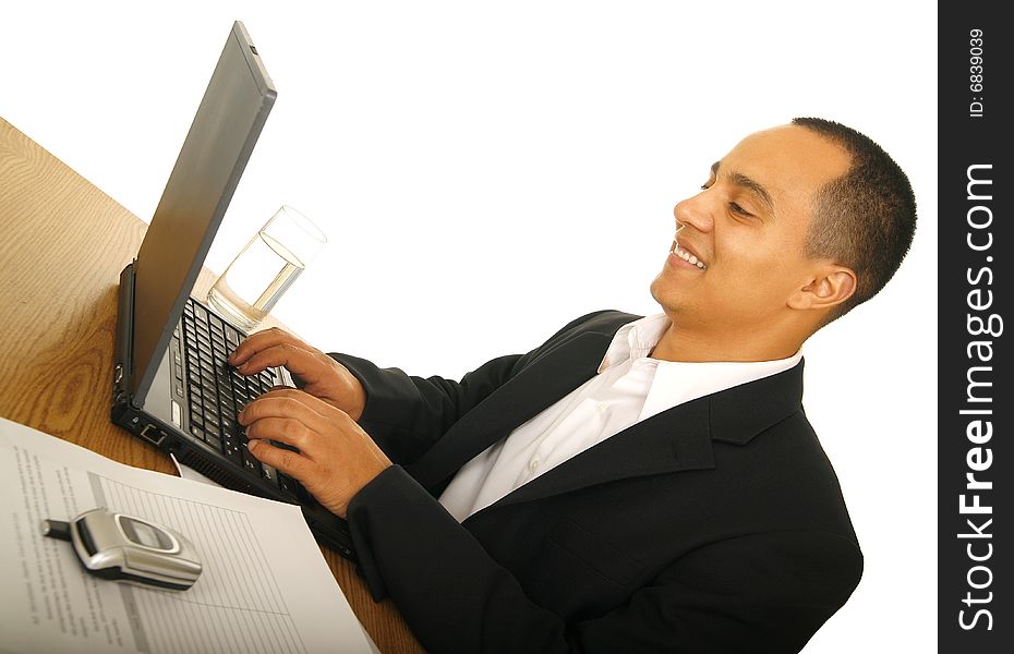 Isolated on white shot of happy business man typing on his laptop with office desk setting