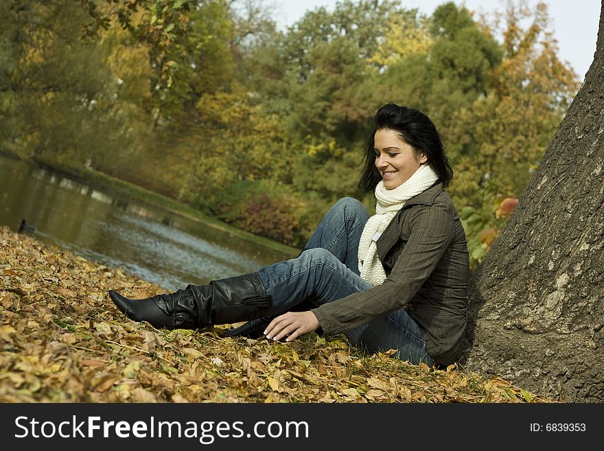 Happy female sitting on the lake with leaves. Happy female sitting on the lake with leaves