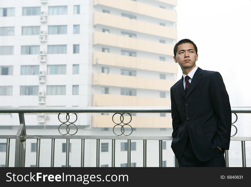 A young asian standing before building. A young asian standing before building