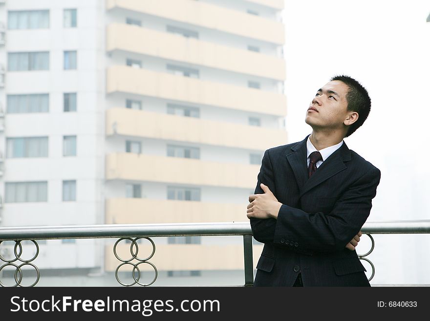 A young asian standing before building. A young asian standing before building