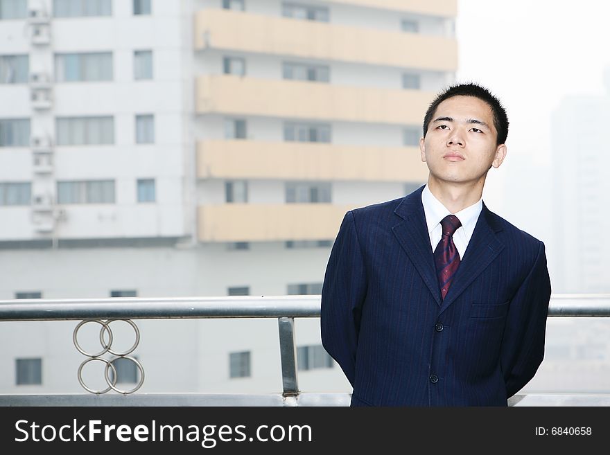 A young asian standing before building. A young asian standing before building