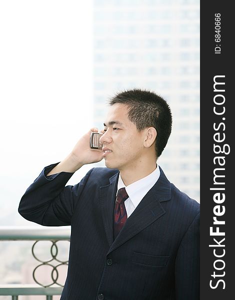 Young asian business man holding mobile phone