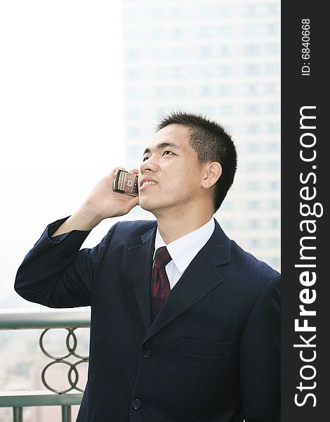 Young asian business man holding mobile phone