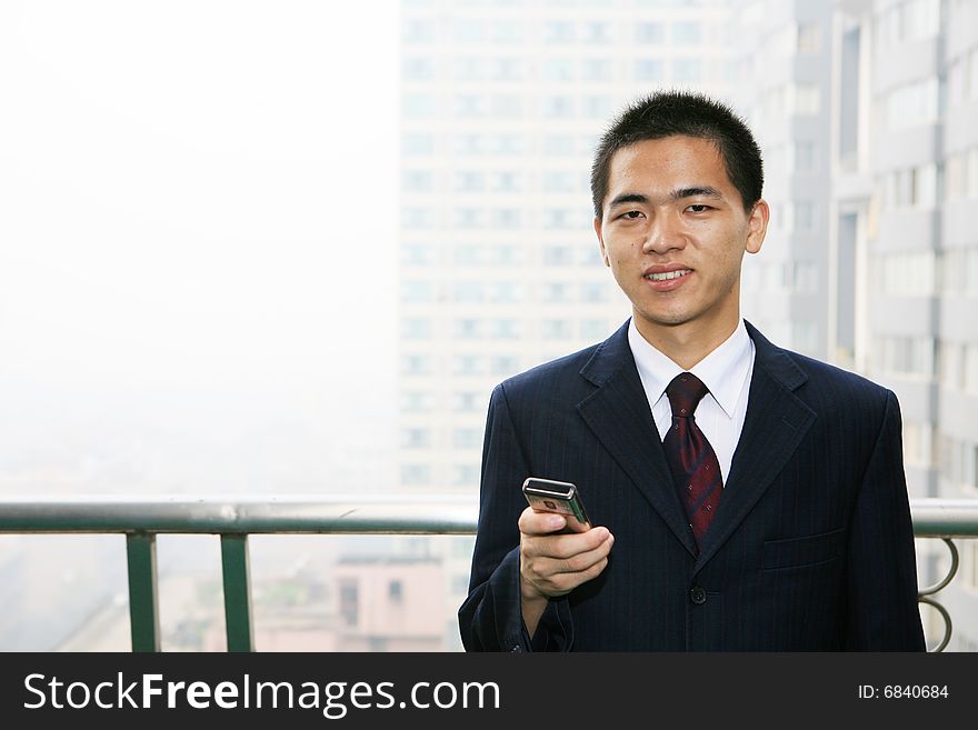 Young asian business man holding mobile phone