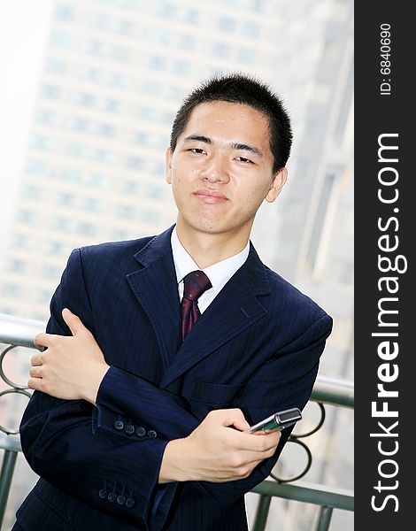 Young asian business man holding mobile phone