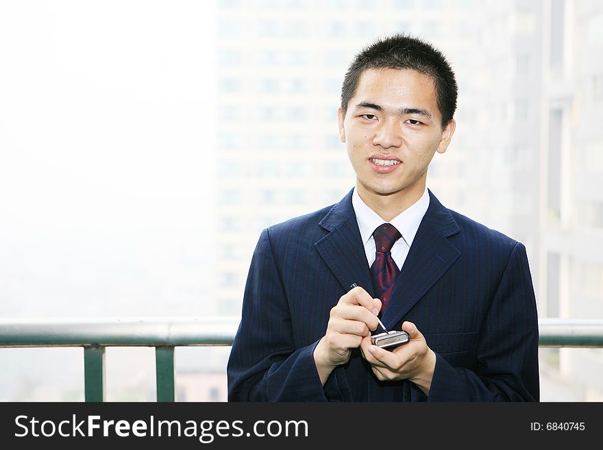 Young business man holding mobile phone