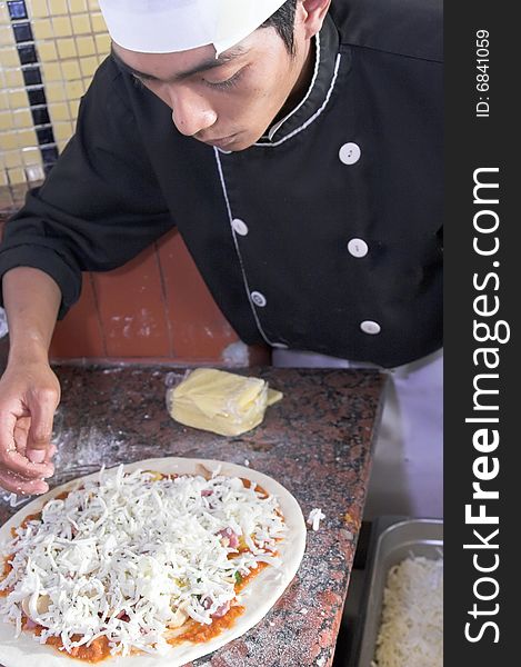 Chef cooking pizza in kitchen