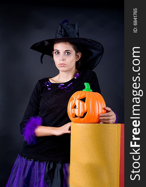 Young halloween witch with pumpink