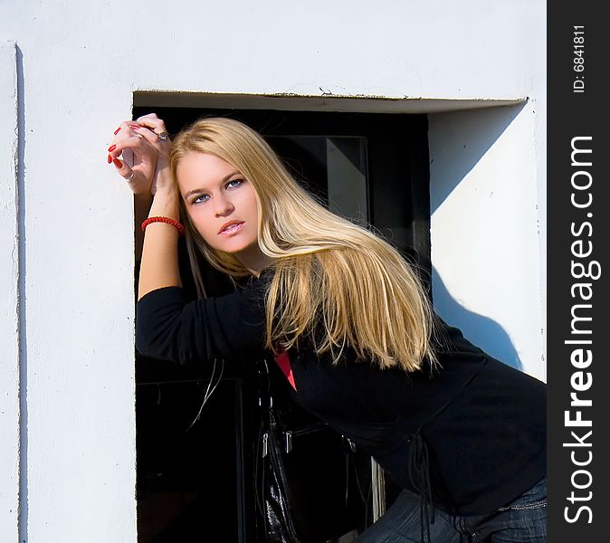 Beautiful Blondy Standing Against Windows