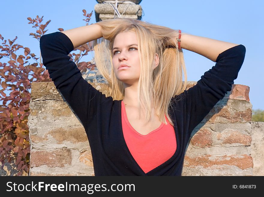 Beautiful blondy woman posing on autumn sunset