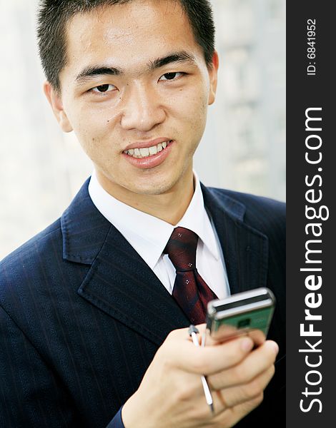 Young business man holding mobile phone