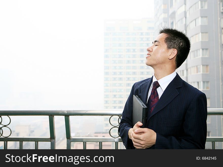 A young asian standing in office building. A young asian standing in office building