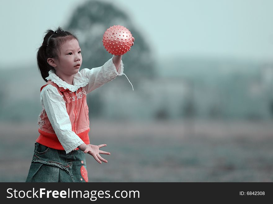 The girl playing ball outside.