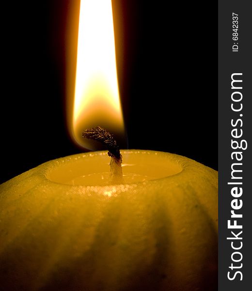 Candle with flame on black background