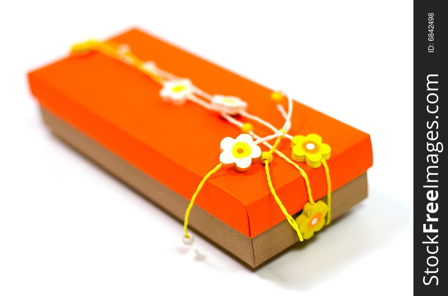 Orange gift box with decoration isolated on white background