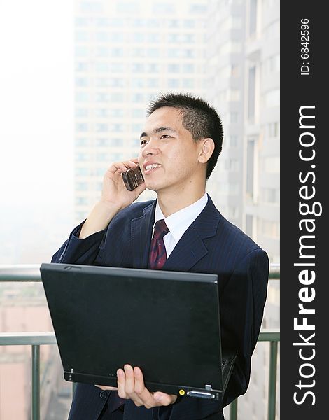 Young asian businessman holding laptop computer