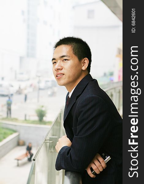 A young asian standing in office building. A young asian standing in office building