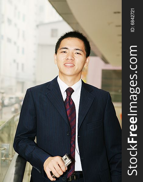 Young asian business man holding mobile phone