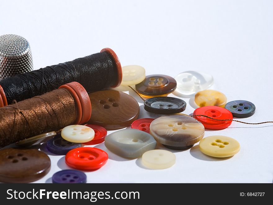 Sewing threads and colorful buttons isolated on white. Sewing threads and colorful buttons isolated on white