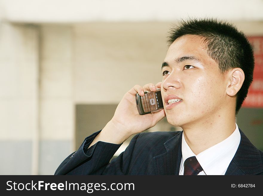 Young business man holding mobile phone