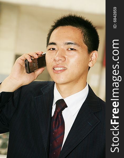 Young asian business man holding mobile phone