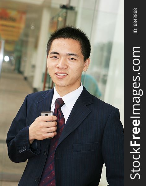 Young business man holding mobile phone