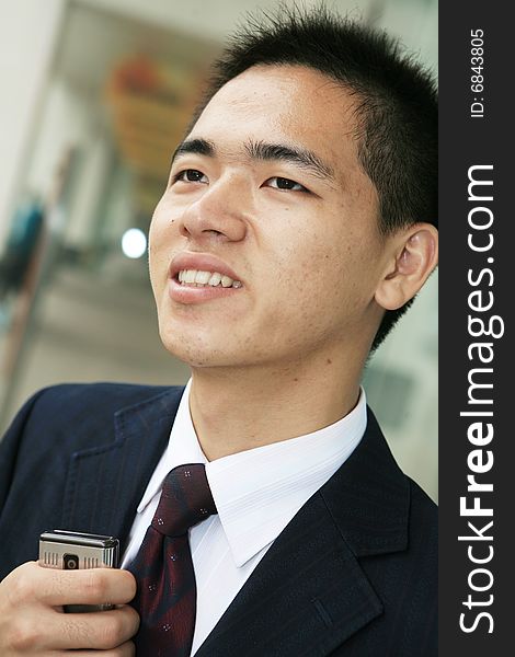 Young asian business man holding mobile phone