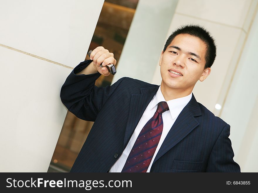 Young business man holding mobile phone