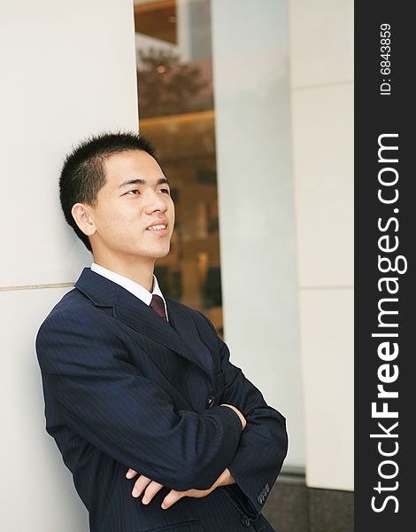 A young asian standing in office building. A young asian standing in office building