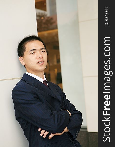 A young asian standing in office building. A young asian standing in office building