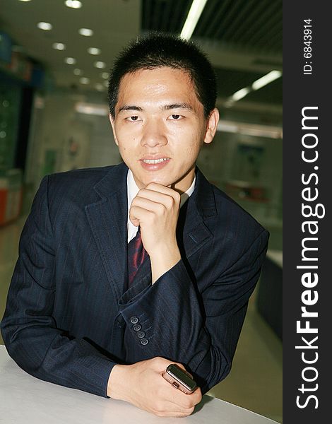 Young asian business man holding mobile phone