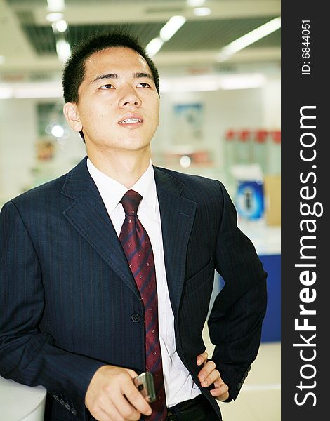 Young asian business man holding mobile phone