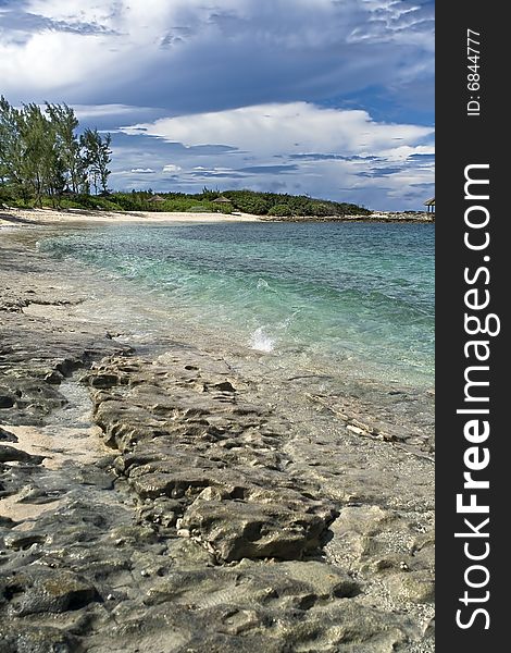 Beautiful tropical shoreline with clear blue and green water and rocky shore.