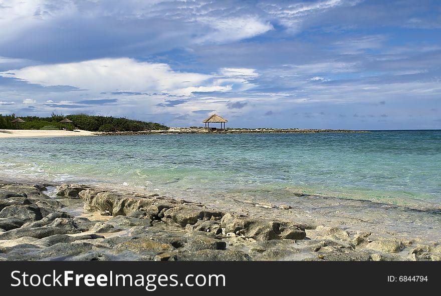 Topical beach with clear green water and rocky shoreline. Topical beach with clear green water and rocky shoreline.