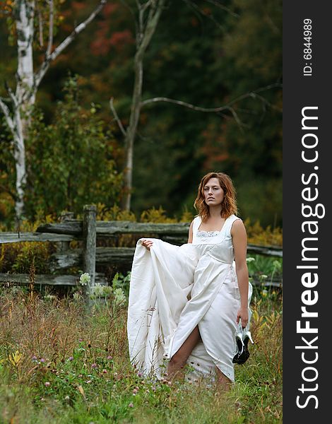 Female wearing wedding dress, natural setting