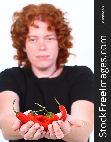 Red head woman holding stack of red chilli peppers. Red head woman holding stack of red chilli peppers