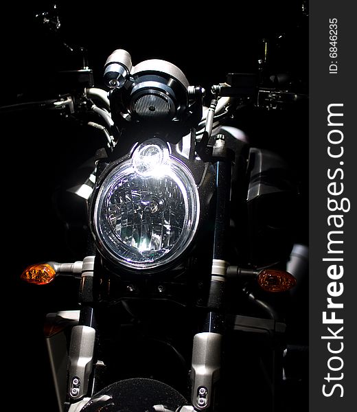 Headlight of new legend bike against a dark background. Headlight of new legend bike against a dark background.