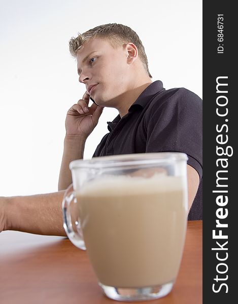 Man busy on cell phone with tea cup