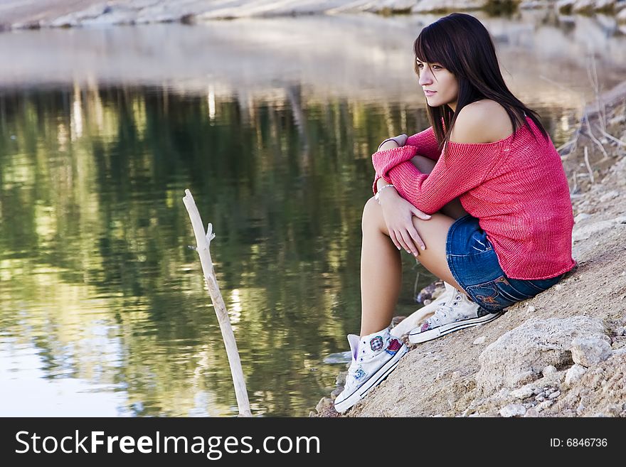 Young beautiful woman relaxing near water. Young beautiful woman relaxing near water.